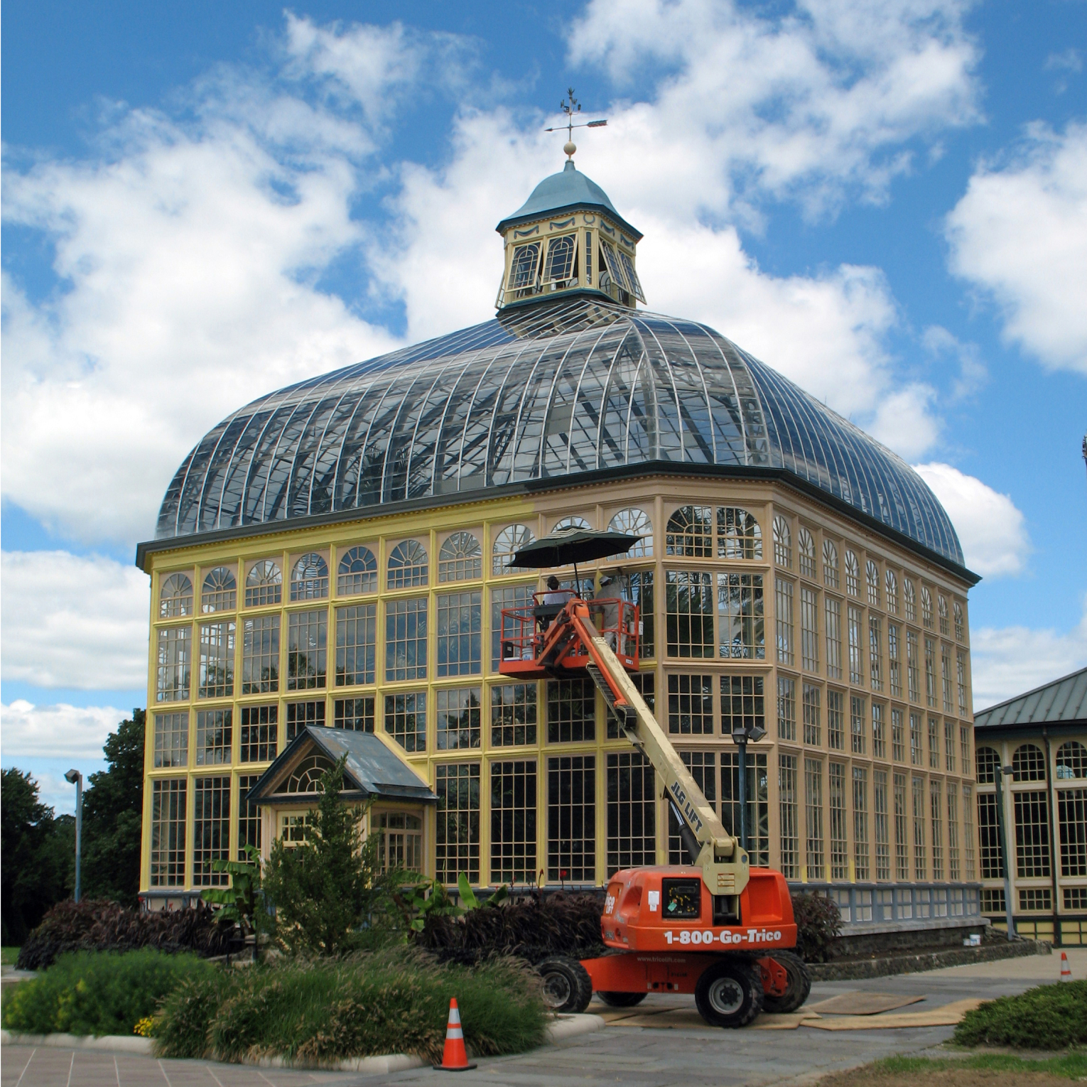 A boom lift with workers outside of the Palm House