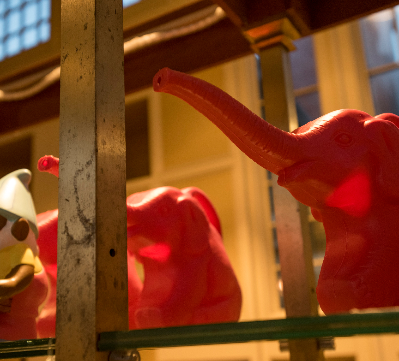Gift shop display of pink elephant watering cans and a small garden gnome